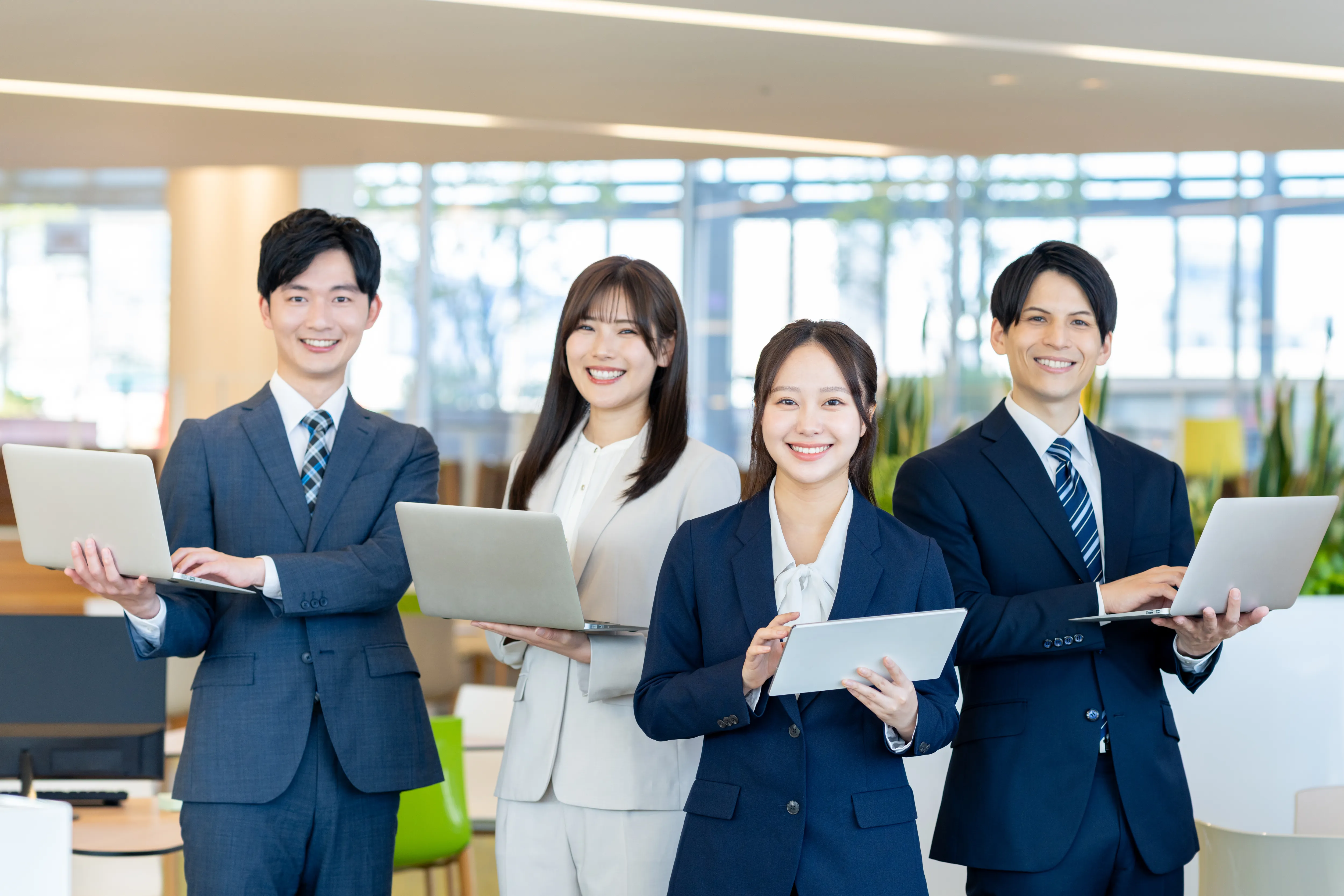 オフィスで端末を持つビジネスパーソン
